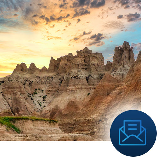 Sunset in the badlands with mail icon representing Tour Marketing Suite creating your email marketing strategy.